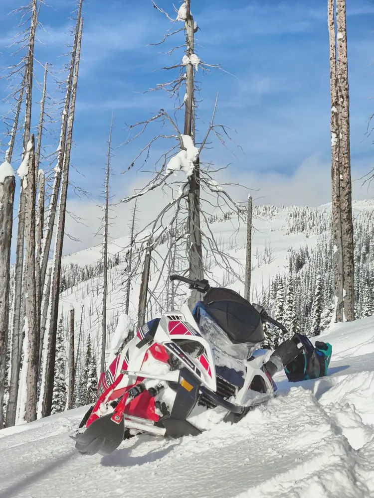 The Sidewinder parked in deep snow in a burnt forest